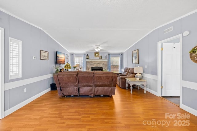 living room featuring ceiling fan, hardwood / wood-style floors, lofted ceiling, and crown molding