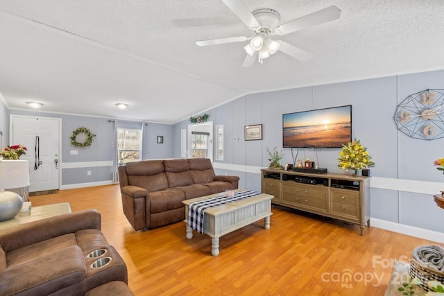 living room featuring vaulted ceiling, a textured ceiling, light wood-type flooring, and ceiling fan