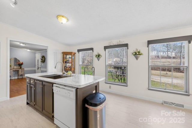 kitchen with white dishwasher, a healthy amount of sunlight, sink, and a kitchen island with sink