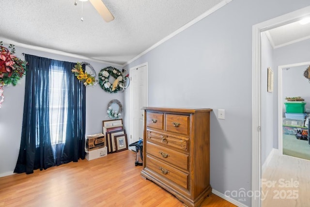 interior space with a textured ceiling, ceiling fan, ornamental molding, and light hardwood / wood-style flooring