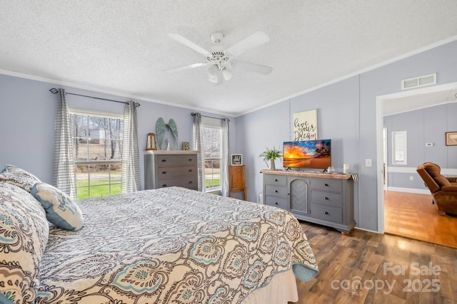 bedroom with dark hardwood / wood-style floors, a textured ceiling, ceiling fan, and ornamental molding