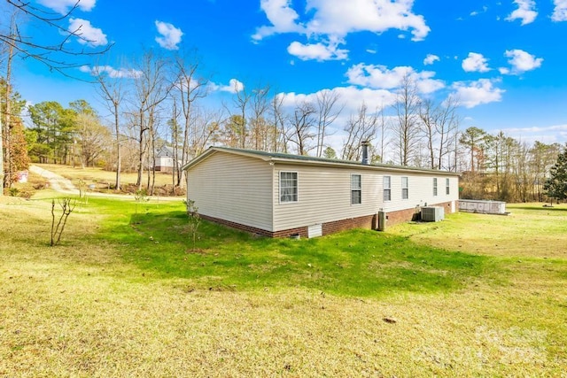 view of property exterior featuring a yard and central AC