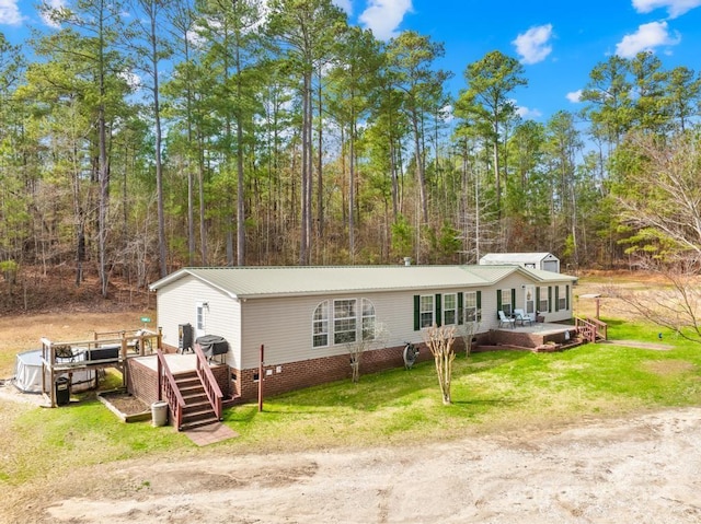 view of front facade with a deck and a front lawn