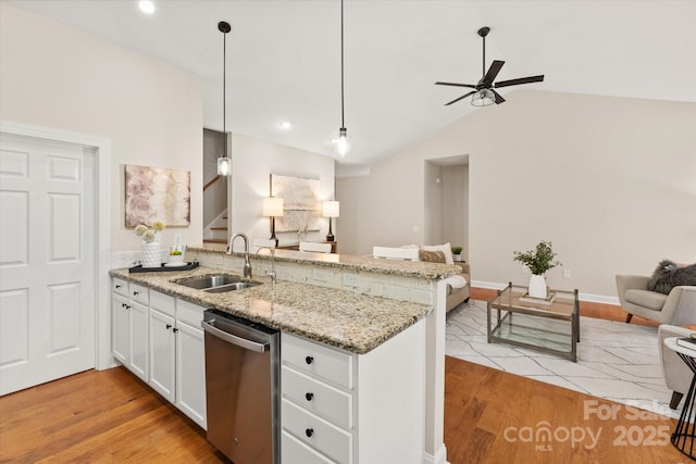 kitchen with white cabinets, dishwasher, open floor plan, decorative light fixtures, and a sink