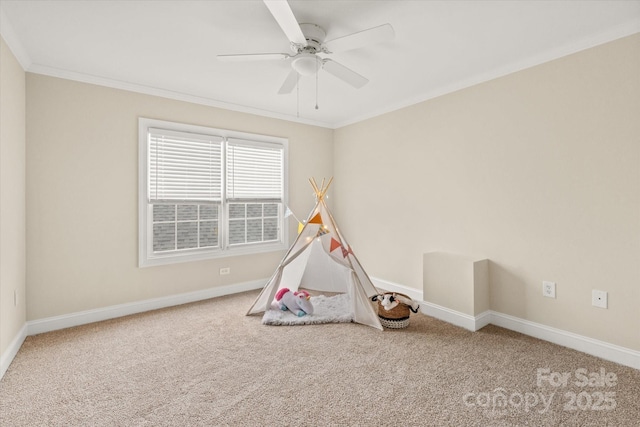 game room featuring a ceiling fan, carpet, crown molding, and baseboards