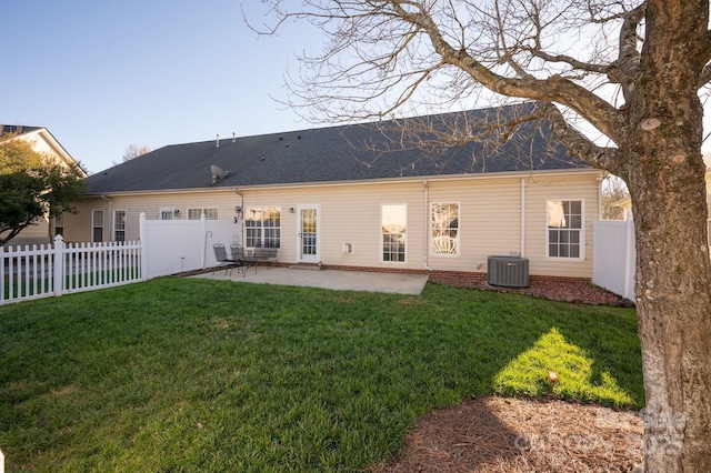 rear view of house with a patio, a lawn, cooling unit, and a fenced backyard