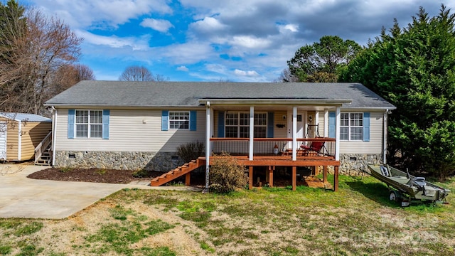 back of property with an outdoor structure, concrete driveway, stairway, crawl space, and a lawn