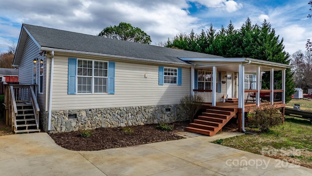 view of front of house featuring covered porch, roof with shingles, crawl space, and stairs