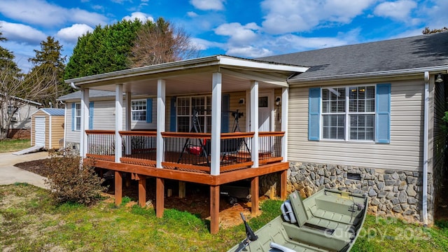 view of front of house featuring crawl space, roof with shingles, an outdoor structure, and a storage shed