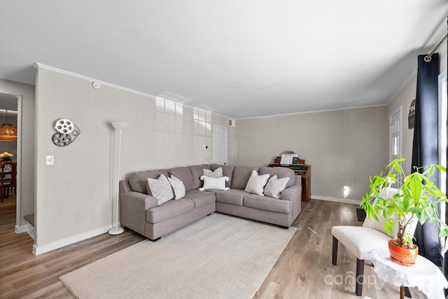 living room with ornamental molding, wood finished floors, and baseboards