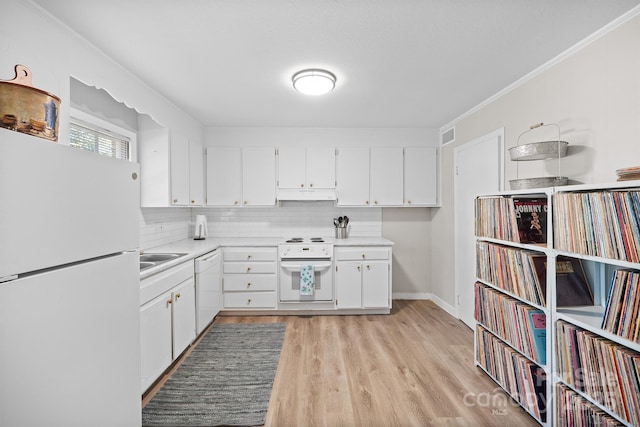 kitchen with tasteful backsplash, white appliances, light countertops, and under cabinet range hood