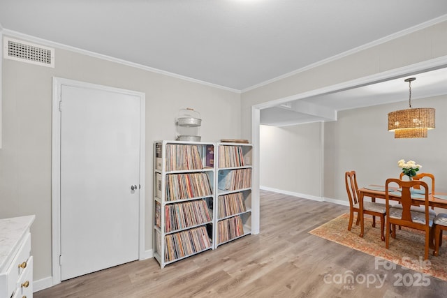 dining area featuring light wood finished floors, baseboards, visible vents, and ornamental molding