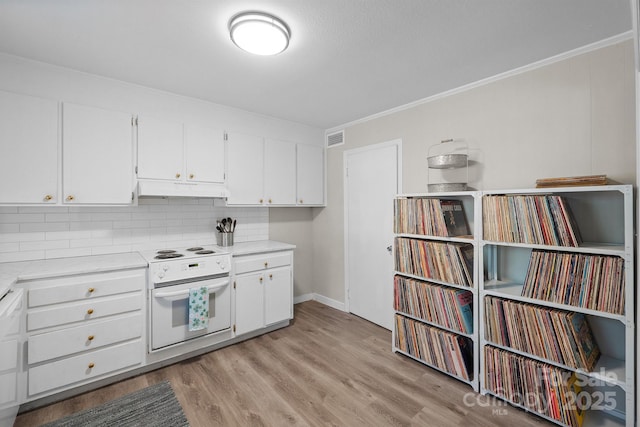 kitchen featuring wall oven, decorative backsplash, light wood-style flooring, light countertops, and under cabinet range hood