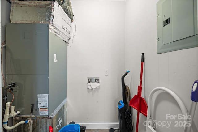 utility room featuring electric panel and heating unit