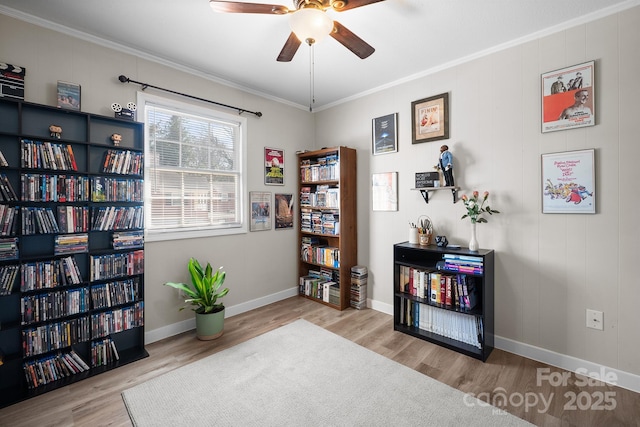 sitting room with ornamental molding, ceiling fan, baseboards, and wood finished floors