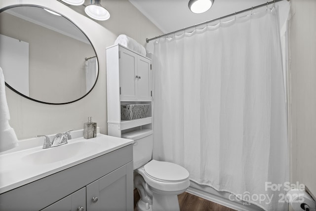 bathroom with vanity, wood finished floors, toilet, and crown molding