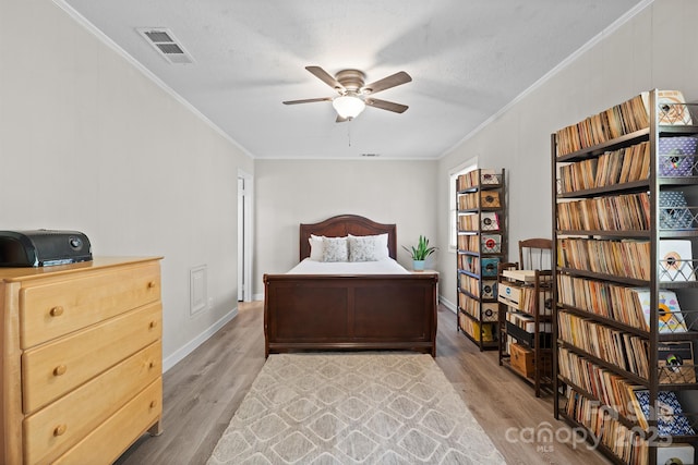 bedroom with ornamental molding, visible vents, and wood finished floors