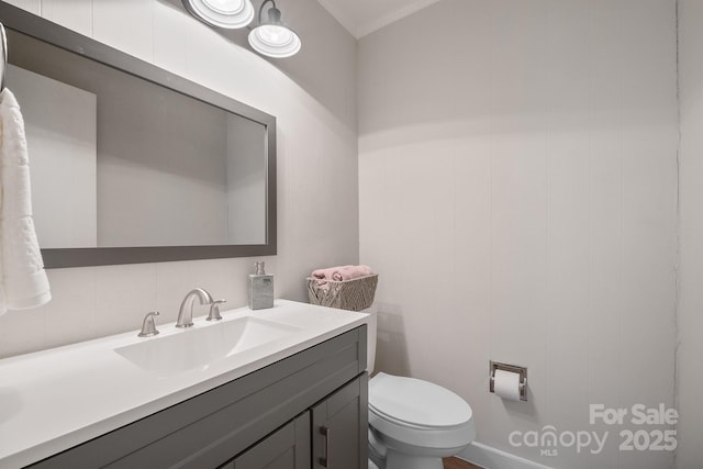 bathroom with toilet, tasteful backsplash, ornamental molding, and vanity