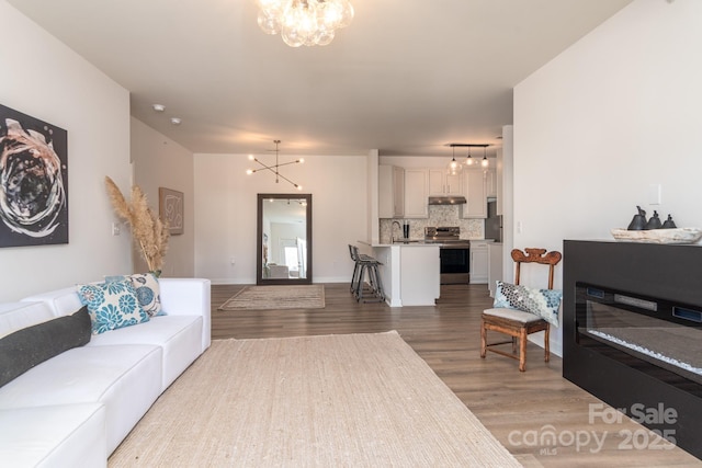 living room featuring hardwood / wood-style floors, sink, and a chandelier