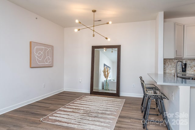 unfurnished dining area with sink, dark wood-type flooring, and a chandelier