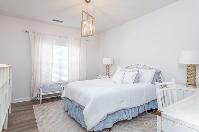 bedroom featuring dark hardwood / wood-style flooring and a notable chandelier