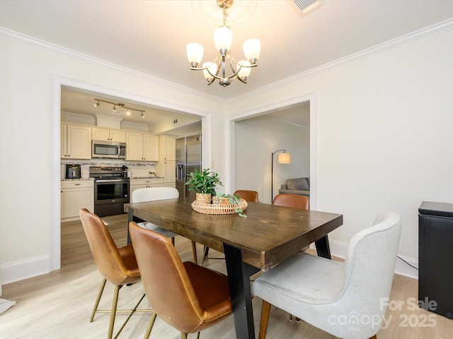 dining space featuring crown molding, light wood finished floors, visible vents, and a notable chandelier