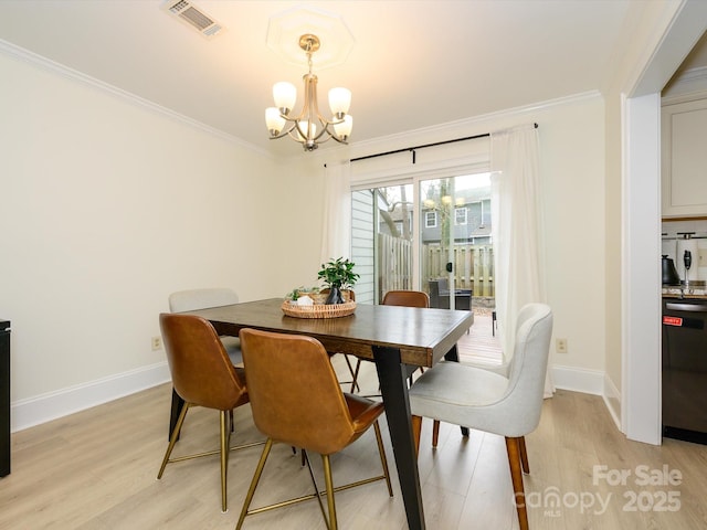 dining room featuring crown molding, light wood finished floors, visible vents, and a notable chandelier