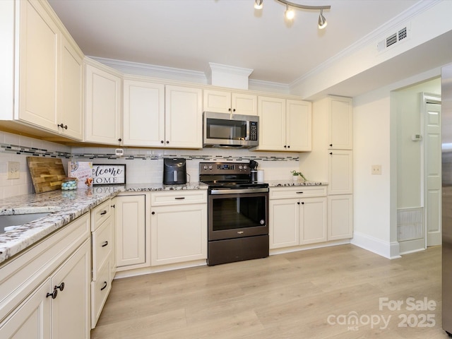 kitchen with light wood finished floors, visible vents, decorative backsplash, stainless steel appliances, and crown molding