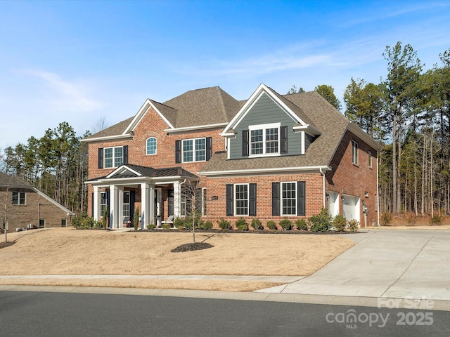 view of front of home featuring a garage, driveway, brick siding, and roof with shingles