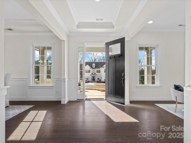 foyer with a wealth of natural light, a wainscoted wall, and wood finished floors