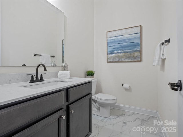 bathroom featuring marble finish floor, vanity, toilet, and baseboards