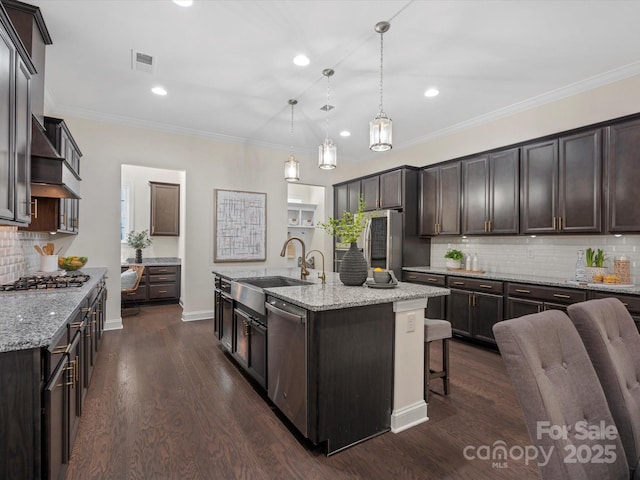 kitchen featuring visible vents, dark wood-style flooring, stainless steel appliances, dark brown cabinets, and a sink