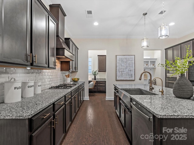 kitchen with stainless steel appliances, a sink, visible vents, ornamental molding, and wall chimney range hood