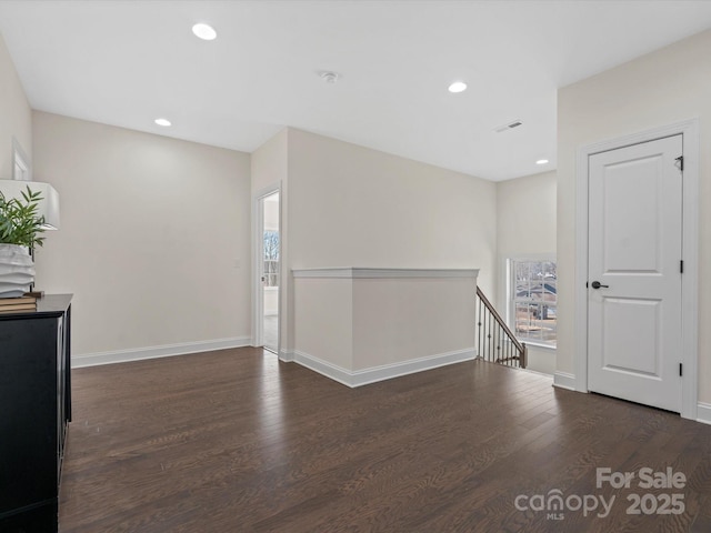 spare room featuring recessed lighting, baseboards, and wood finished floors