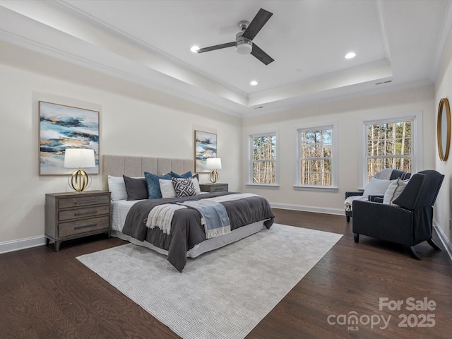 bedroom with baseboards, a tray ceiling, and dark wood-type flooring