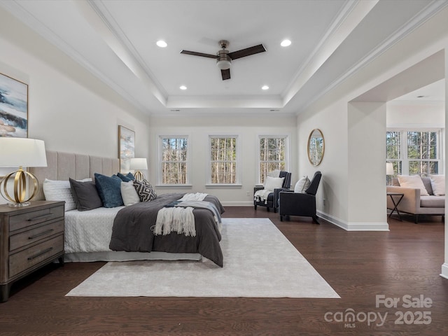 bedroom featuring a tray ceiling, crown molding, dark wood finished floors, recessed lighting, and baseboards