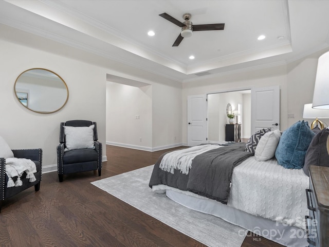 bedroom with baseboards, a tray ceiling, wood finished floors, and recessed lighting