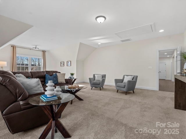 carpeted living room featuring attic access, baseboards, and vaulted ceiling