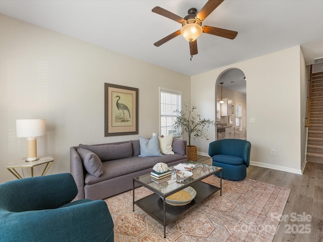 living room with light hardwood / wood-style flooring and ceiling fan