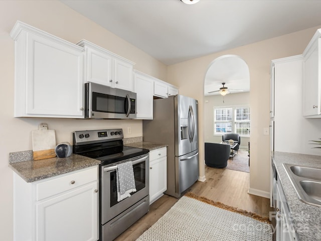 kitchen featuring light wood-type flooring, stainless steel appliances, sink, ceiling fan, and white cabinets