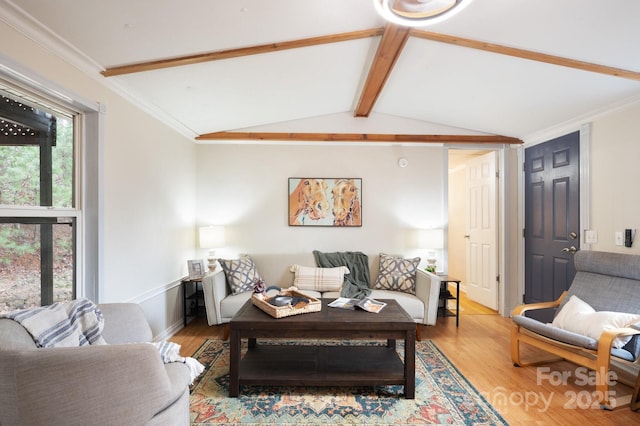 living area featuring vaulted ceiling with beams, ornamental molding, and wood finished floors