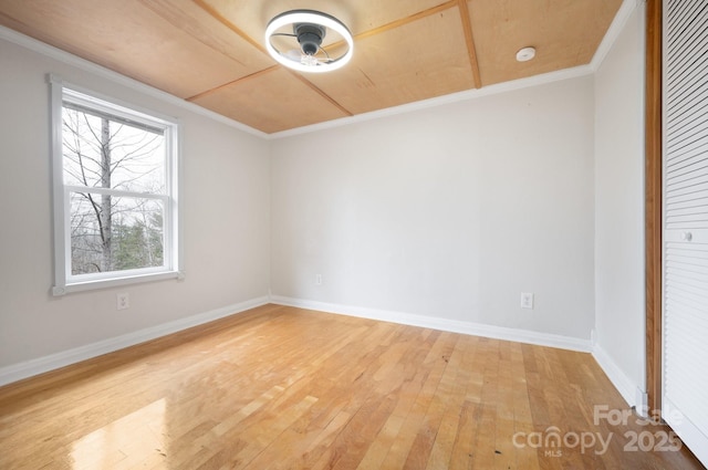 spare room with ornamental molding, hardwood / wood-style floors, and baseboards