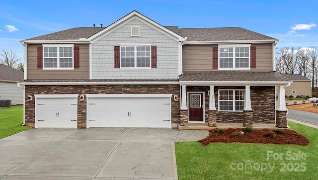 view of front of home featuring a garage, central AC, and a front lawn