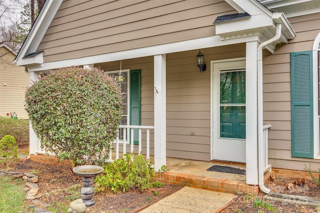 view of exterior entry featuring covered porch