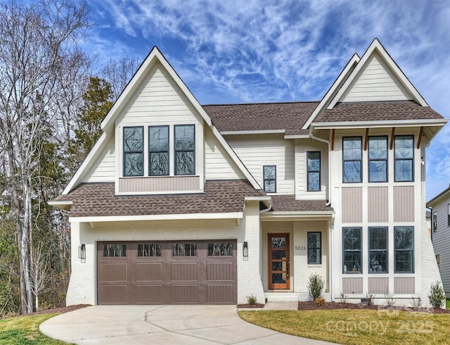 view of front of home featuring concrete driveway, a shingled roof, a front lawn, and an attached garage