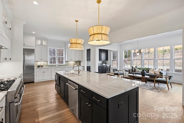 kitchen with white cabinets, dark cabinets, high end appliances, and a sink