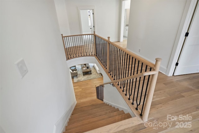 staircase with wood finished floors and baseboards