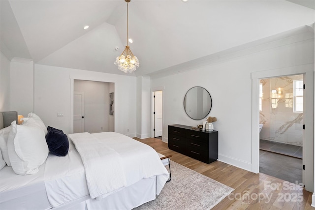 bedroom with a notable chandelier, vaulted ceiling, ensuite bath, light wood-type flooring, and baseboards