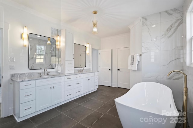 full bathroom with tile patterned flooring, a sink, a freestanding bath, and double vanity