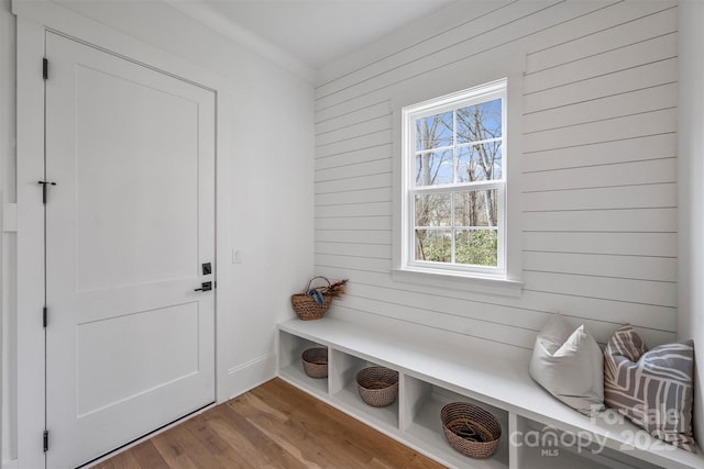 mudroom featuring wood walls and wood finished floors